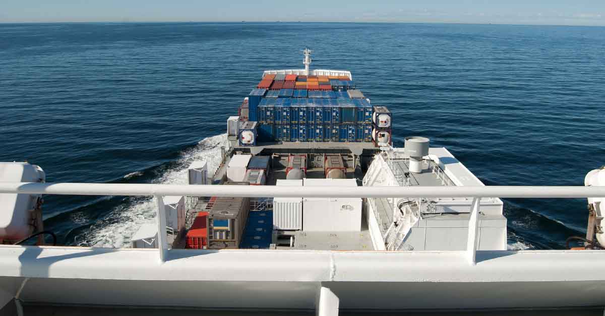 A ship with cargo sailing in a large body of water.