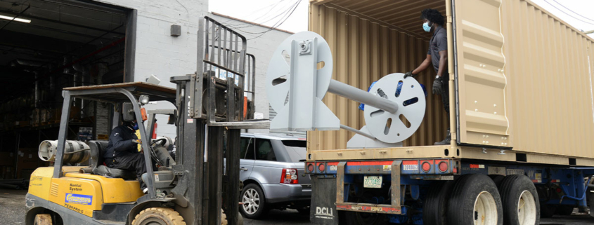 Using forklift to place heavy object inside a semitruck.