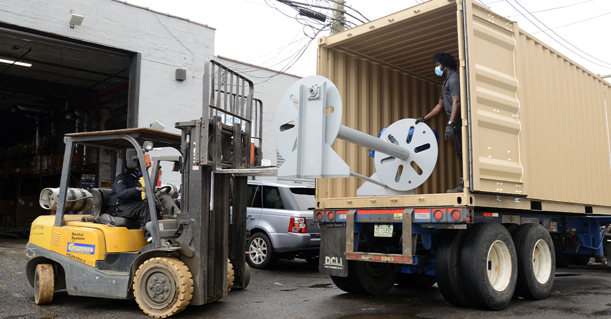 Using forklift to place heavy object inside a semitruck.