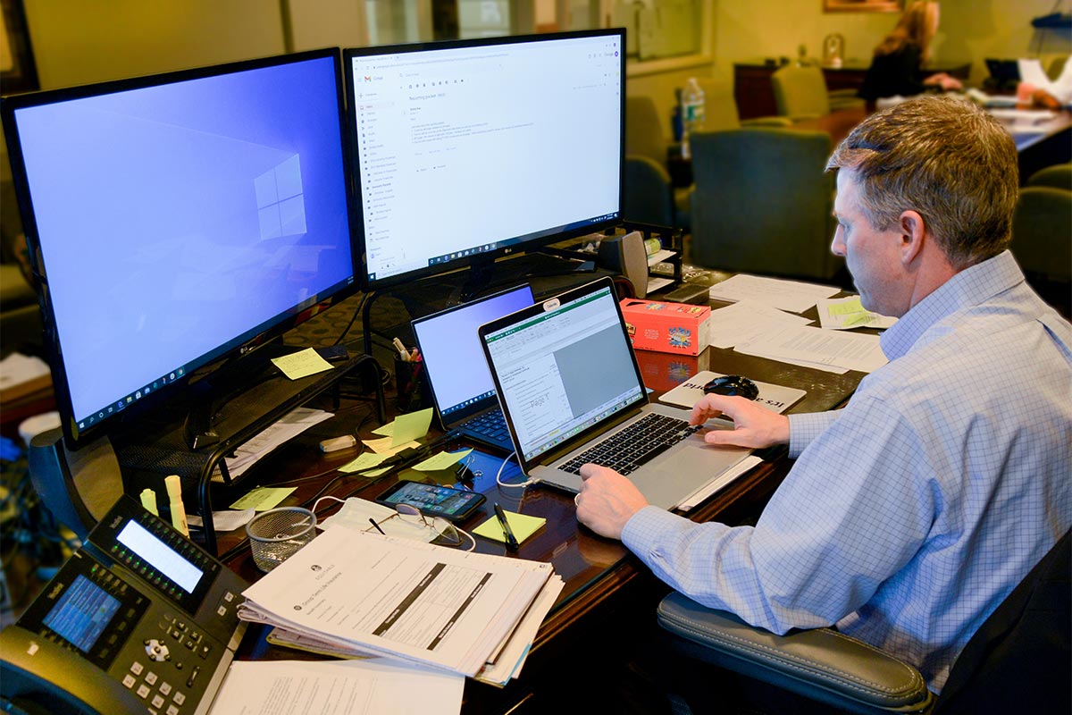 Male Horizon Air Freight working on computer with multiple screens